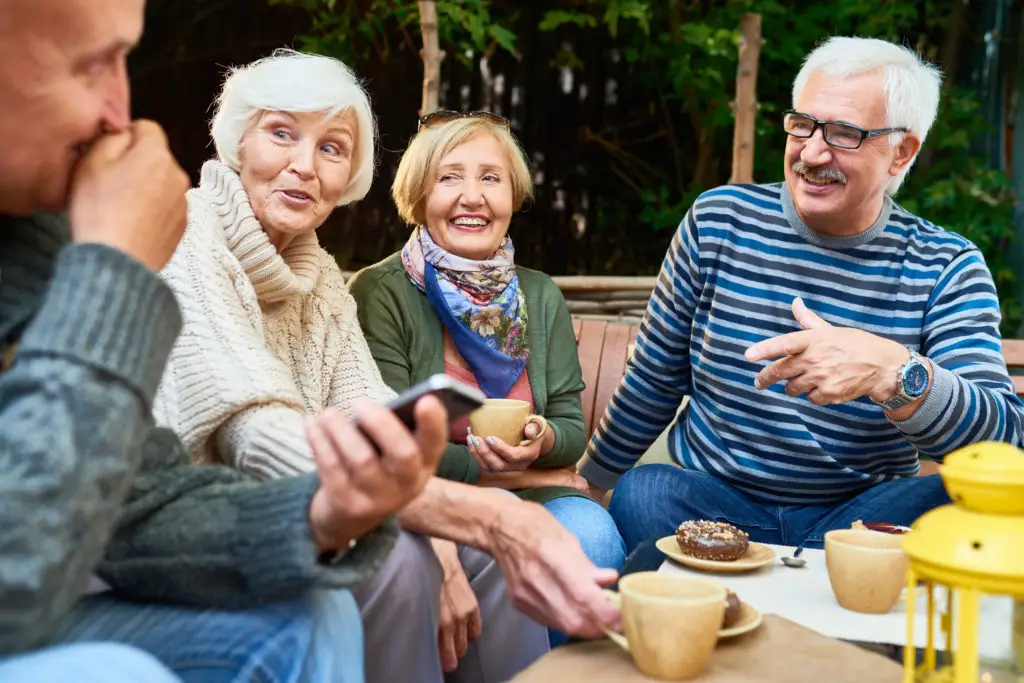 Quatre séniors qui passent un bon moment autour d'un café